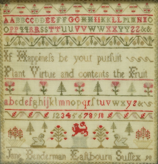 A 19th century sampler by Jane Benderman, Eastbourn, Sussex, 98. Worked in reds and greens on a yellow background, in rows of alphabet, numerals and spot motifs of swans, flowers, trees with a central lion motif, in a ro